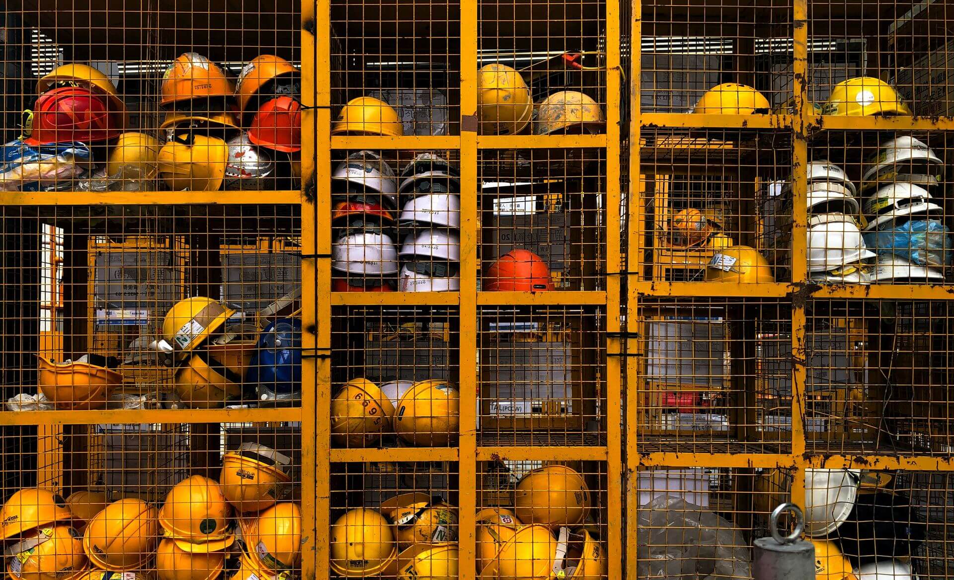 Wire lockers containing yellow construction hard hats