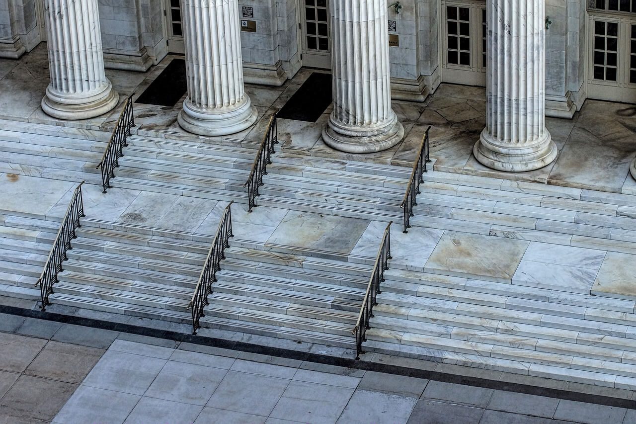 Steps to a courthouse with pillars.