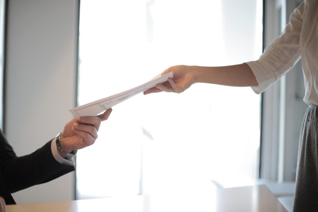 Someone handing documents to a person in an employee category